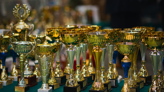 Trophées et médailles sur un bureau pour illustrer les récompenses et challenges commerciaux